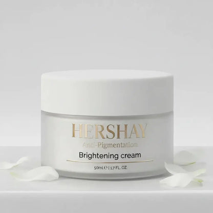 A white cosmetic cream jar labeled HERSHAY Brightening cream, shown on a clean light gray background with a few white flower petals around the base.

